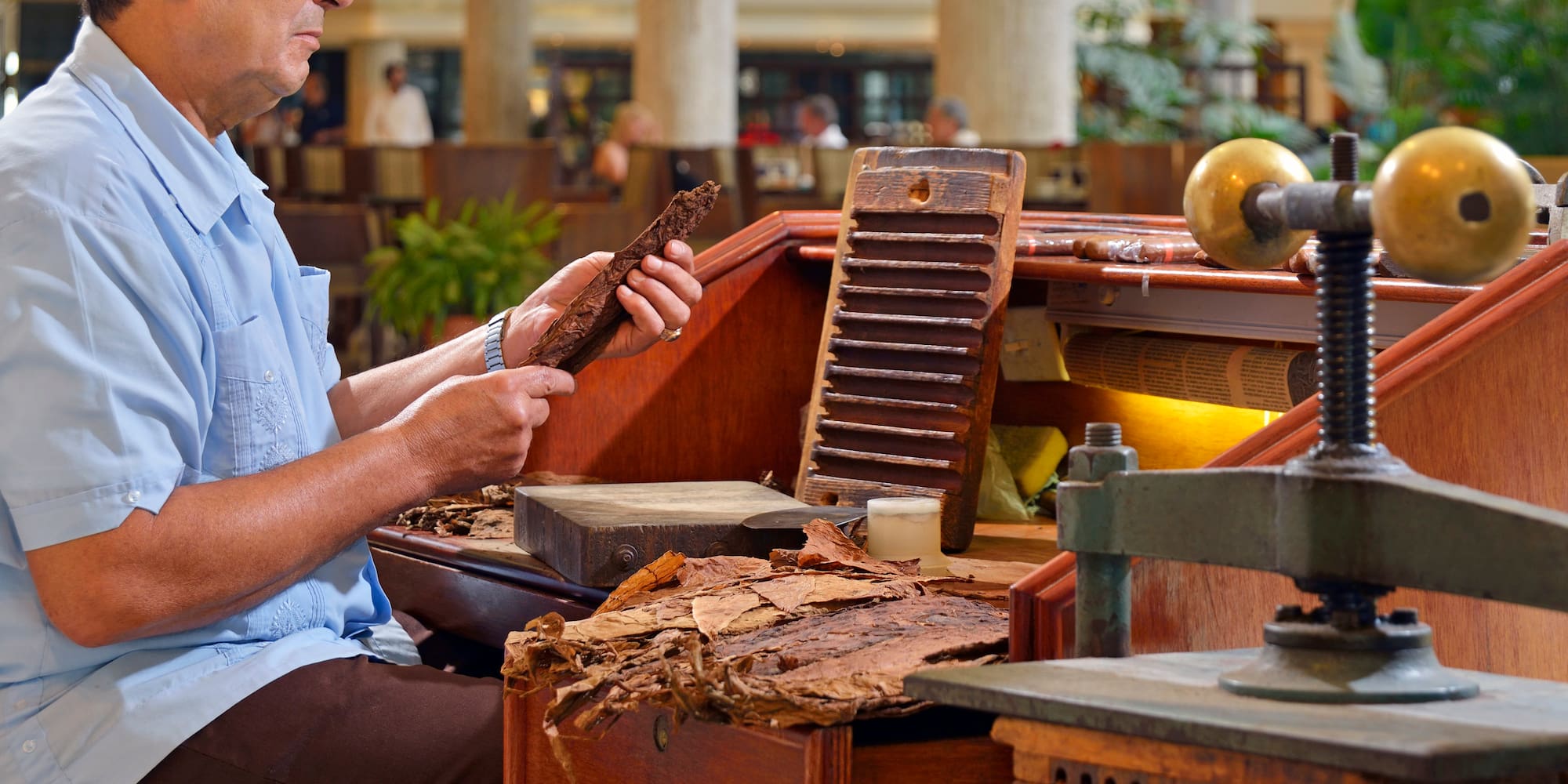 a man sitting at a desk with a piece of wood