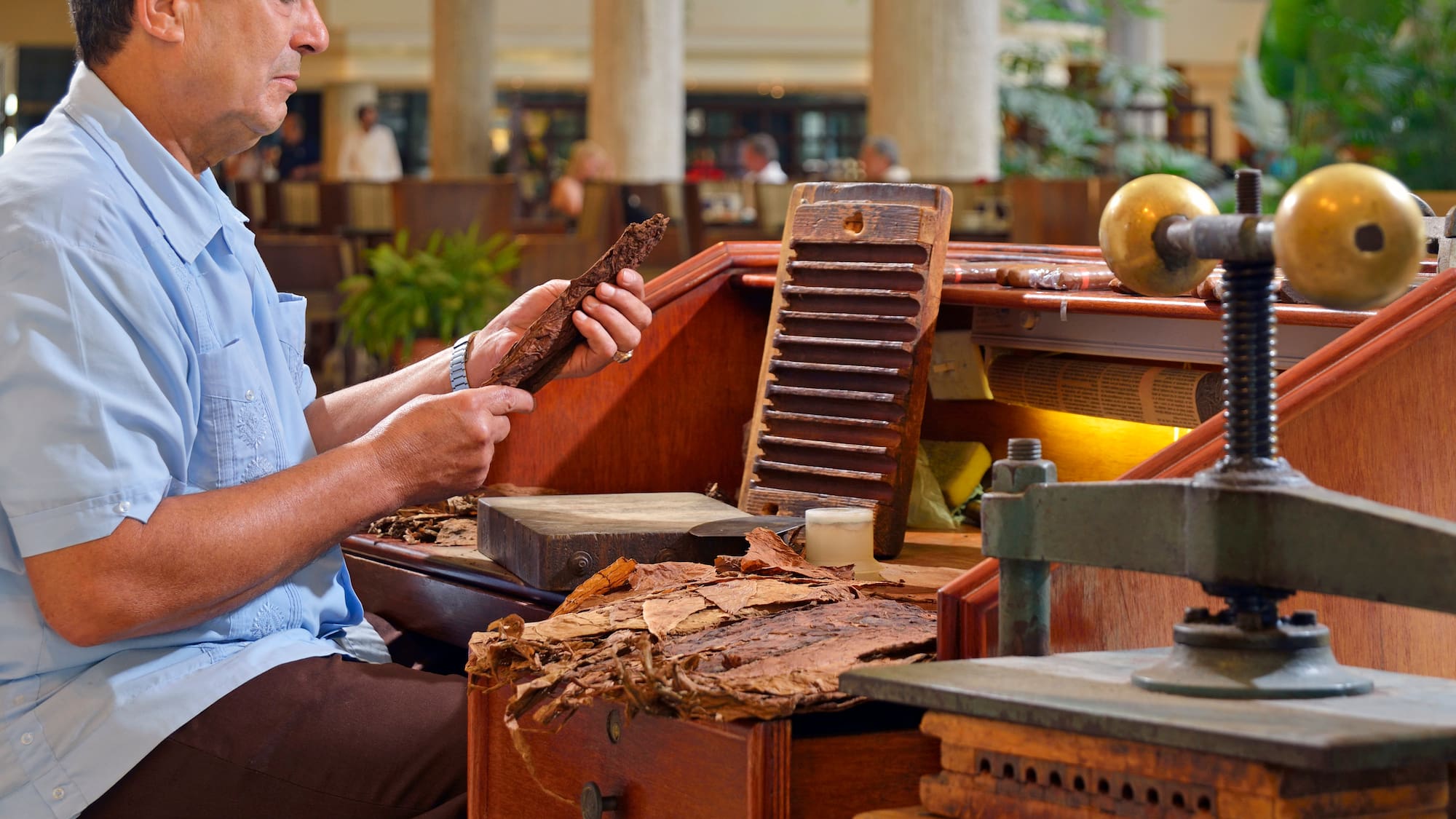 a man sitting at a desk with a piece of wood