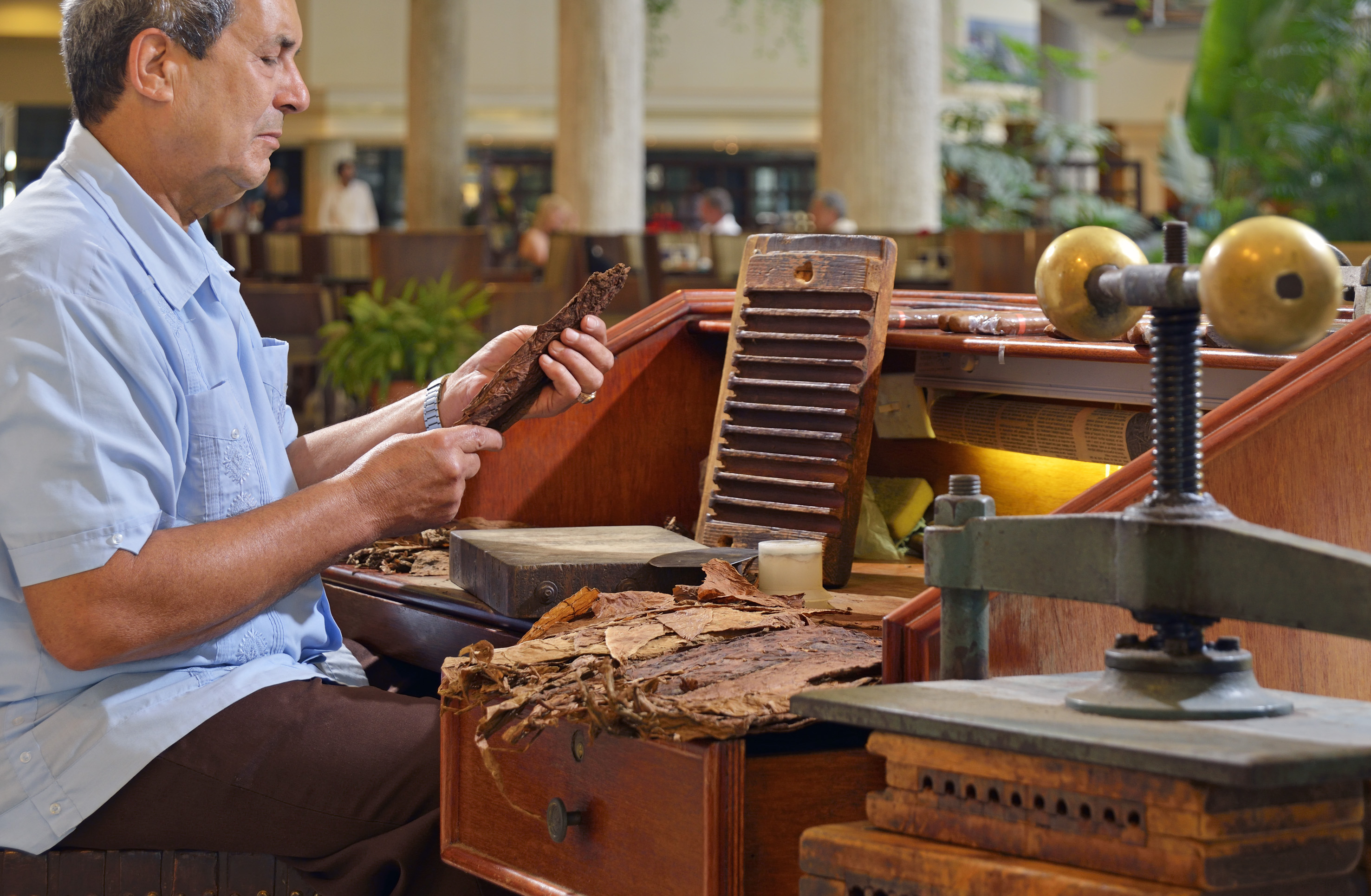 a man sitting at a desk with a piece of wood