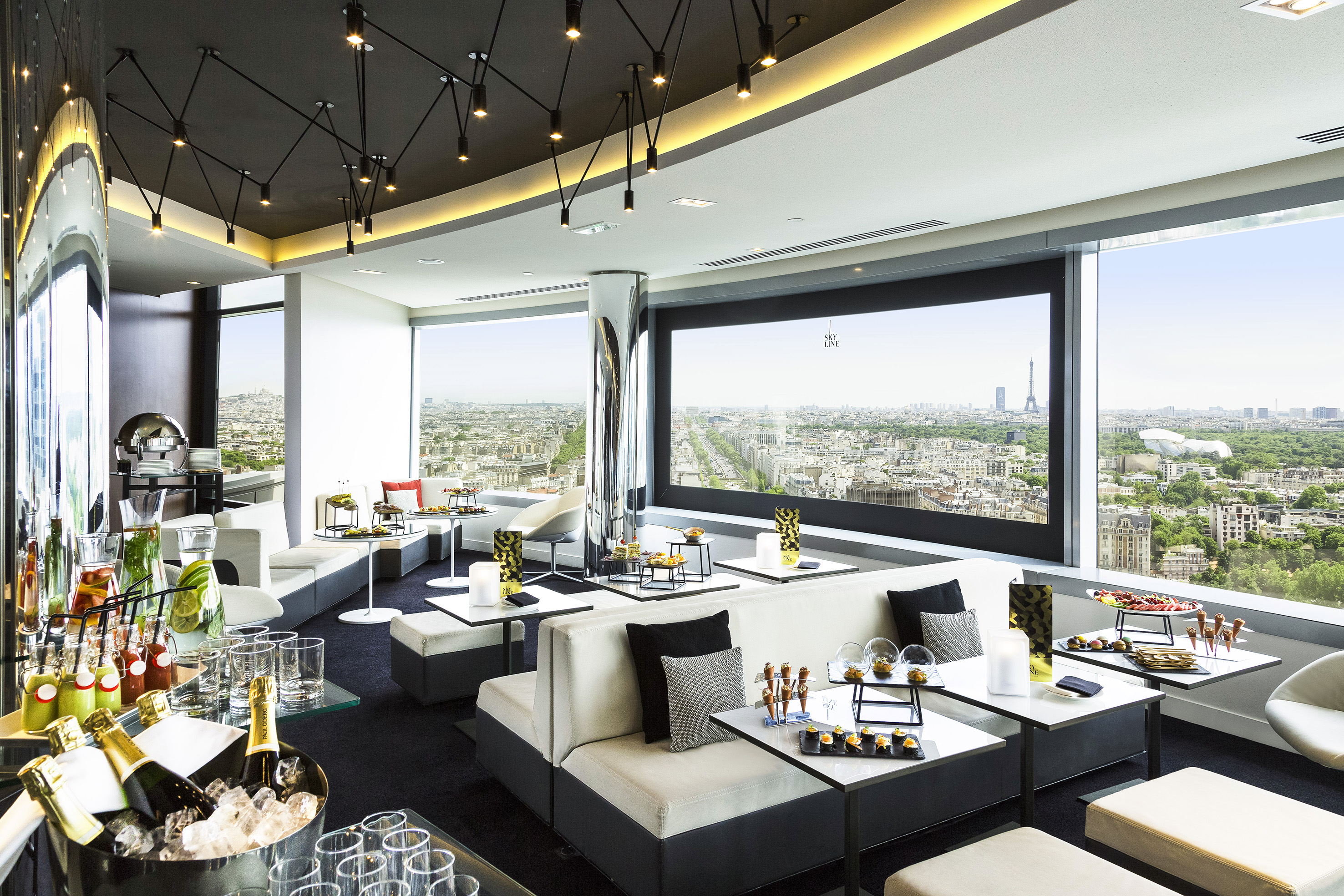 Luxury lounge with panoramic Paris view, Eiffel Tower, drinks, and appetizers.