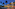 Illuminated Sol Los Fenicios hotel facade with palm trees at dusk.