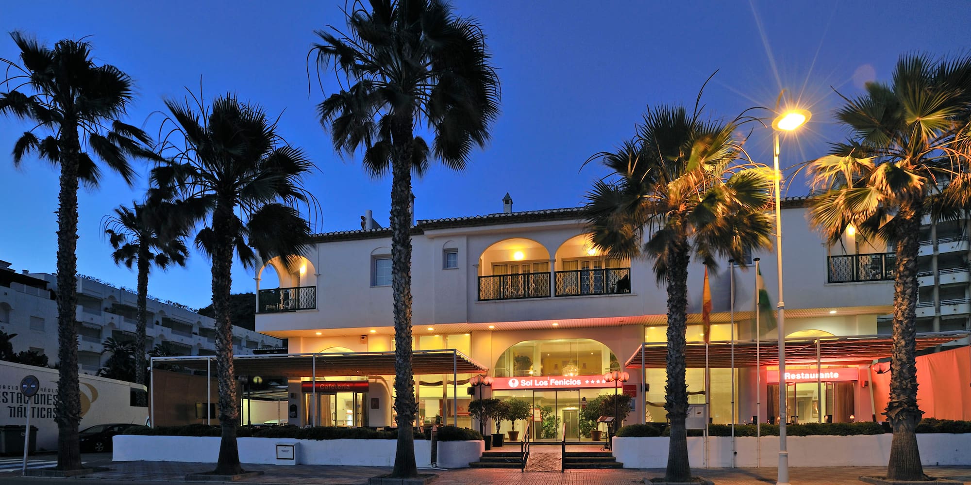 a building with palm trees and a street light