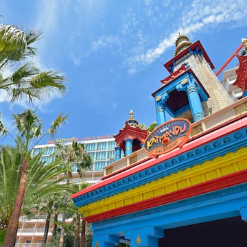 a colorful building with a tower and palm trees
