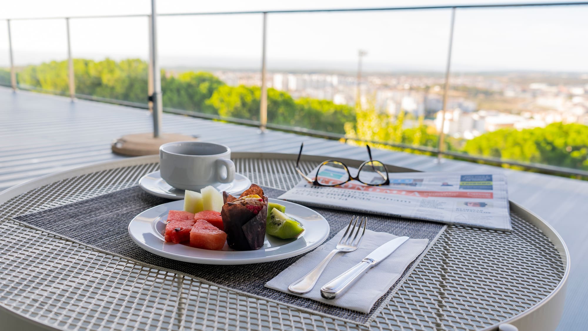 a plate of fruit and a cup of coffee on a table