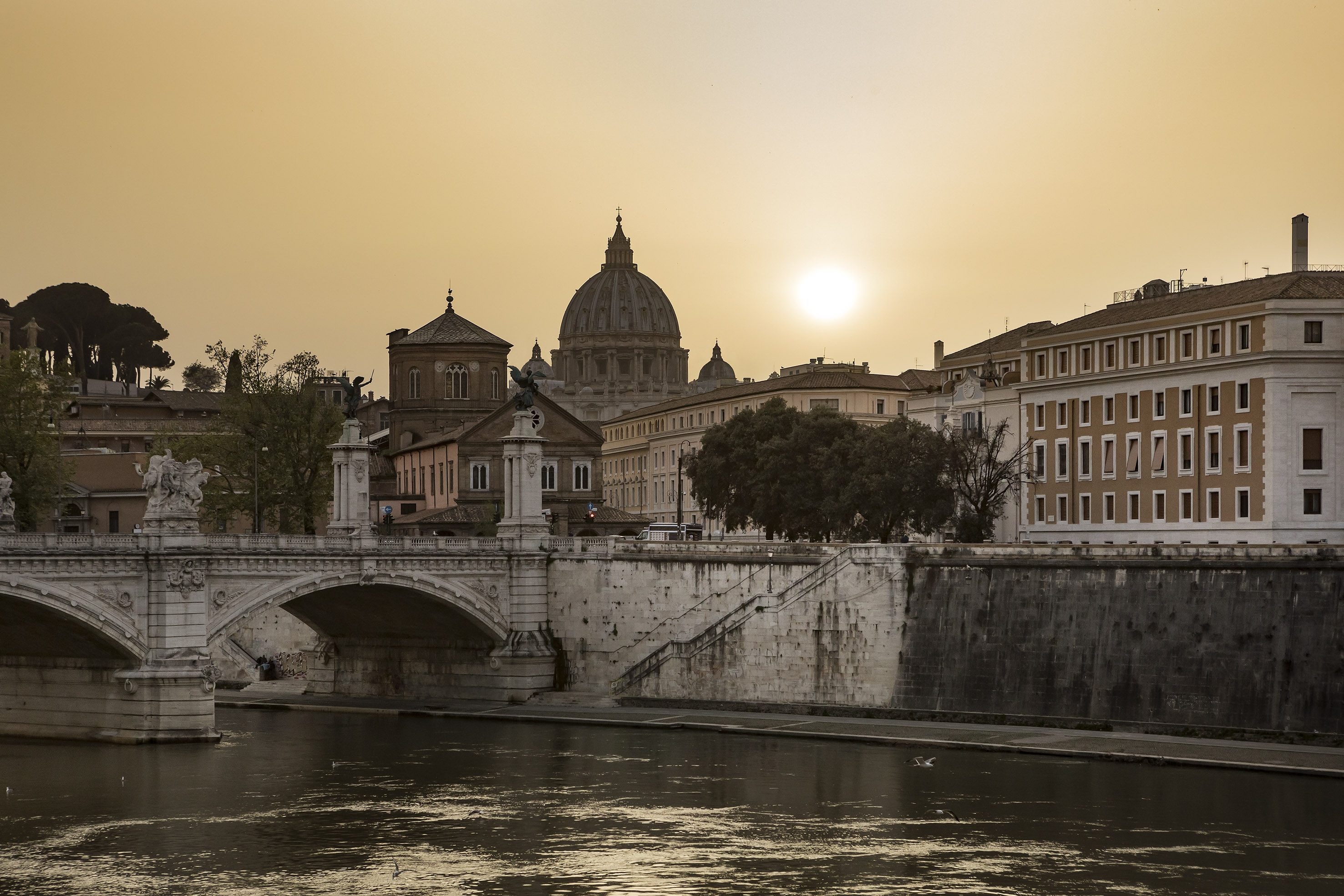 Rome sunset over Tiber River: St. Peter's Basilica dome, Ponte Sant'Angelo.