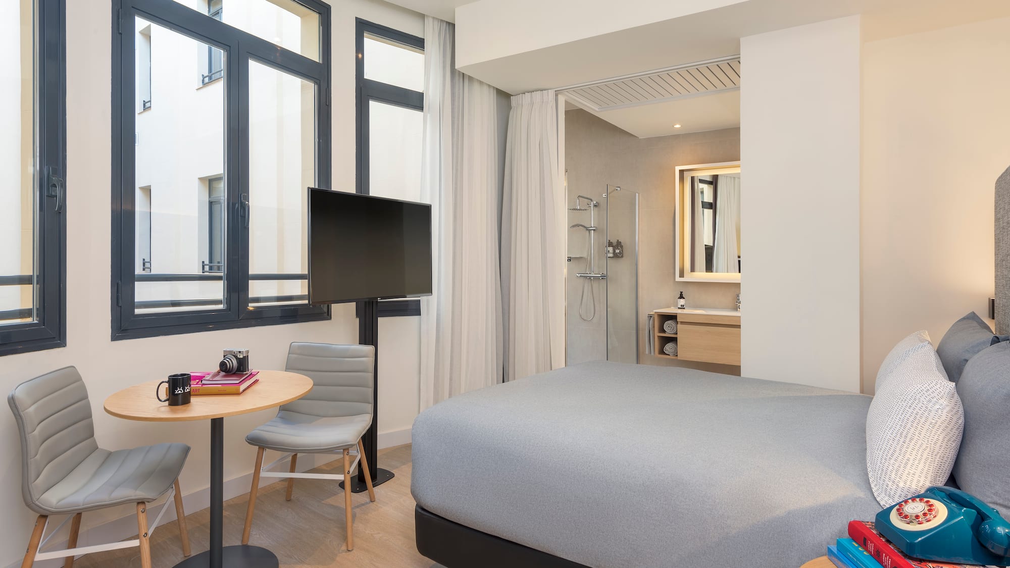 a room with a bed and a table and chairs