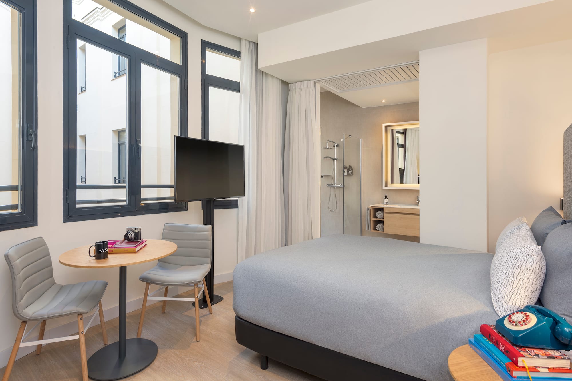 a room with a bed and a table and chairs