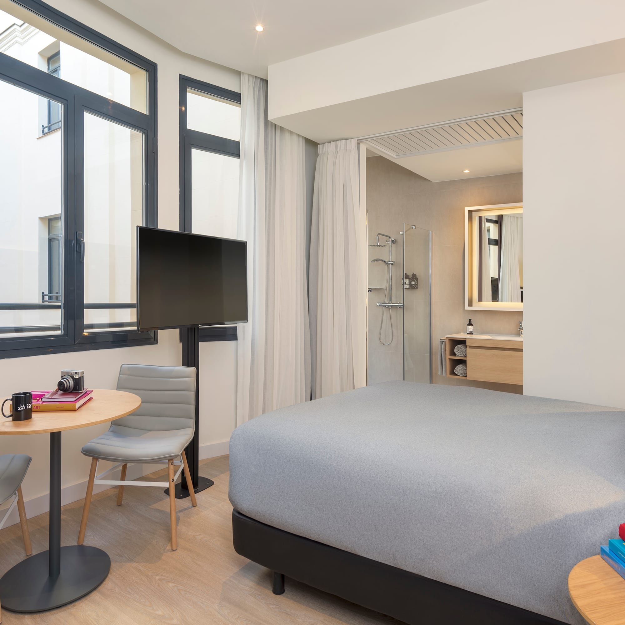 a room with a bed and a table and chairs