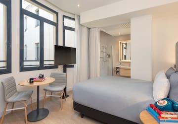 a room with a bed and a table and chairs