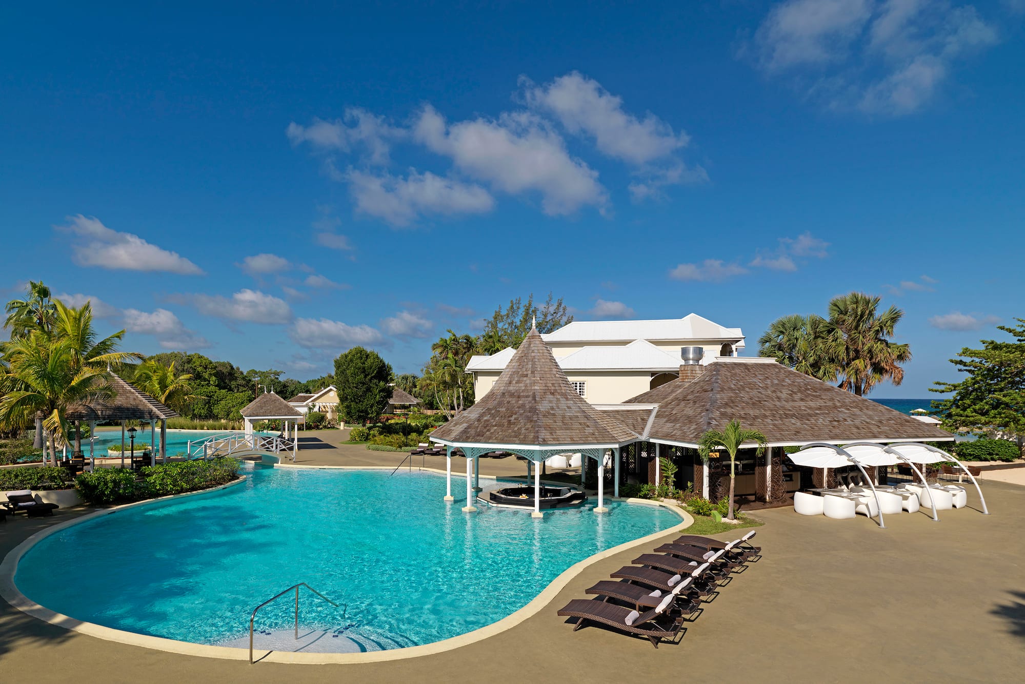 a pool with lounge chairs and a building