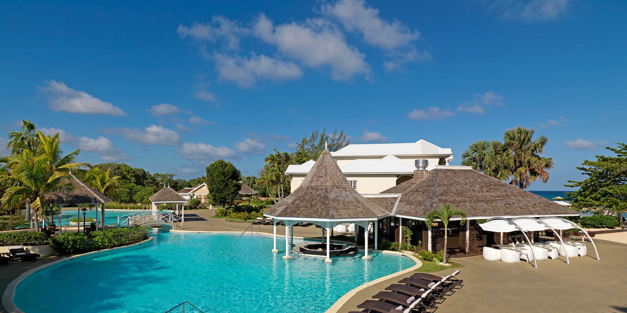 a pool with lounge chairs and a building