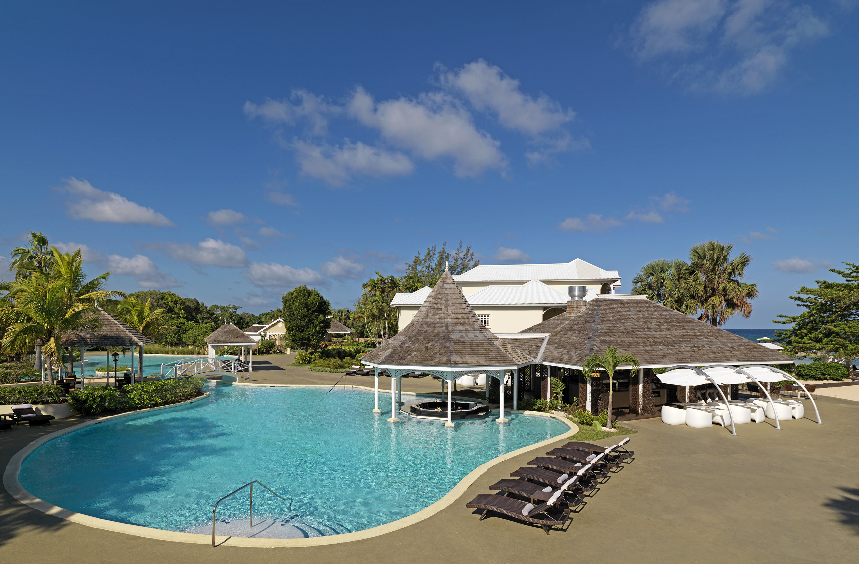 a pool with lounge chairs and a building