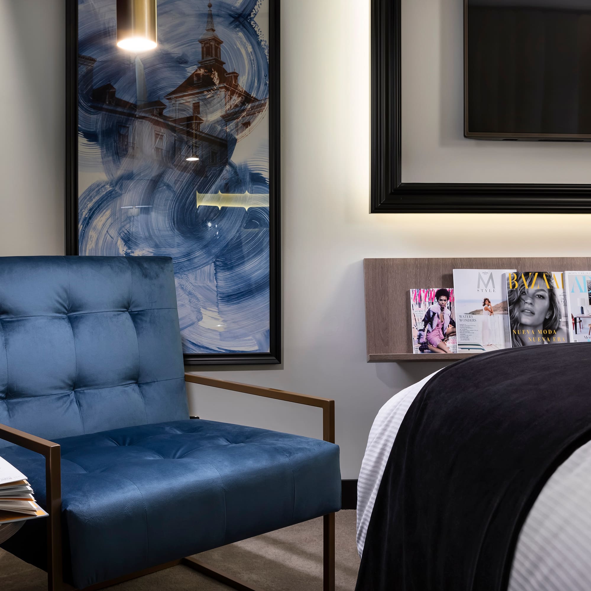 a blue chair next to a bed