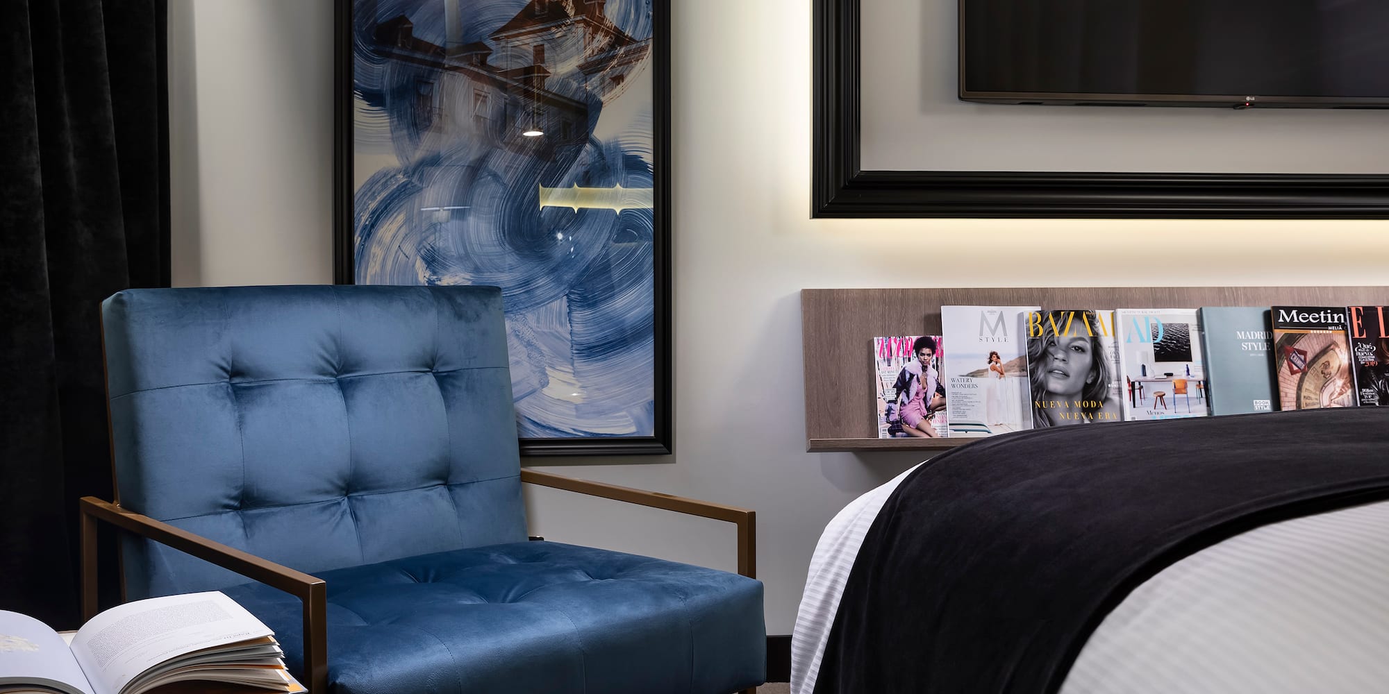 a blue chair next to a bed