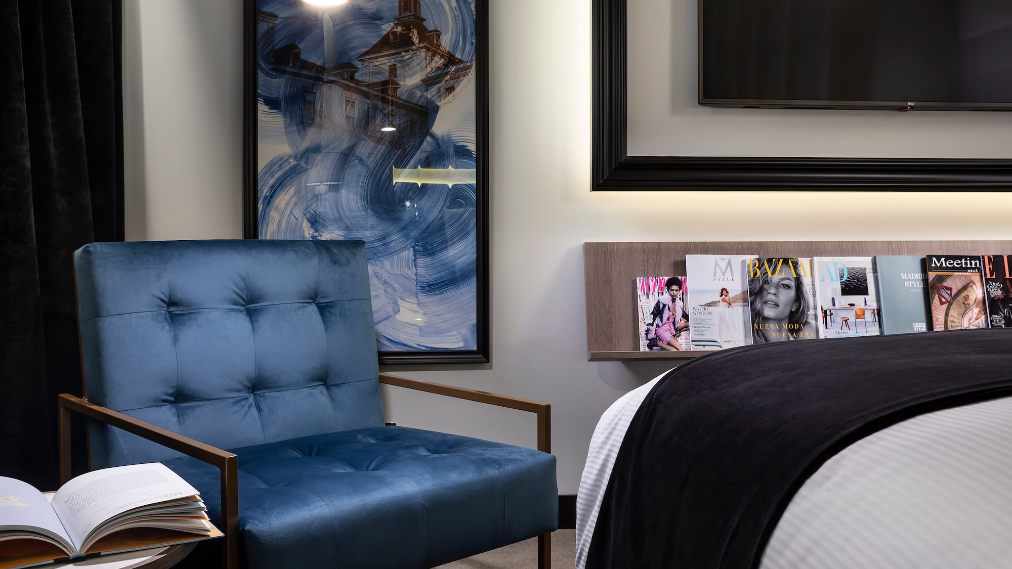 a blue chair next to a bed