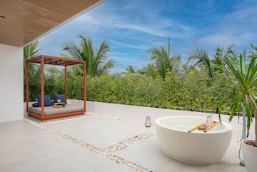 a tub outside with a canopy and a bench