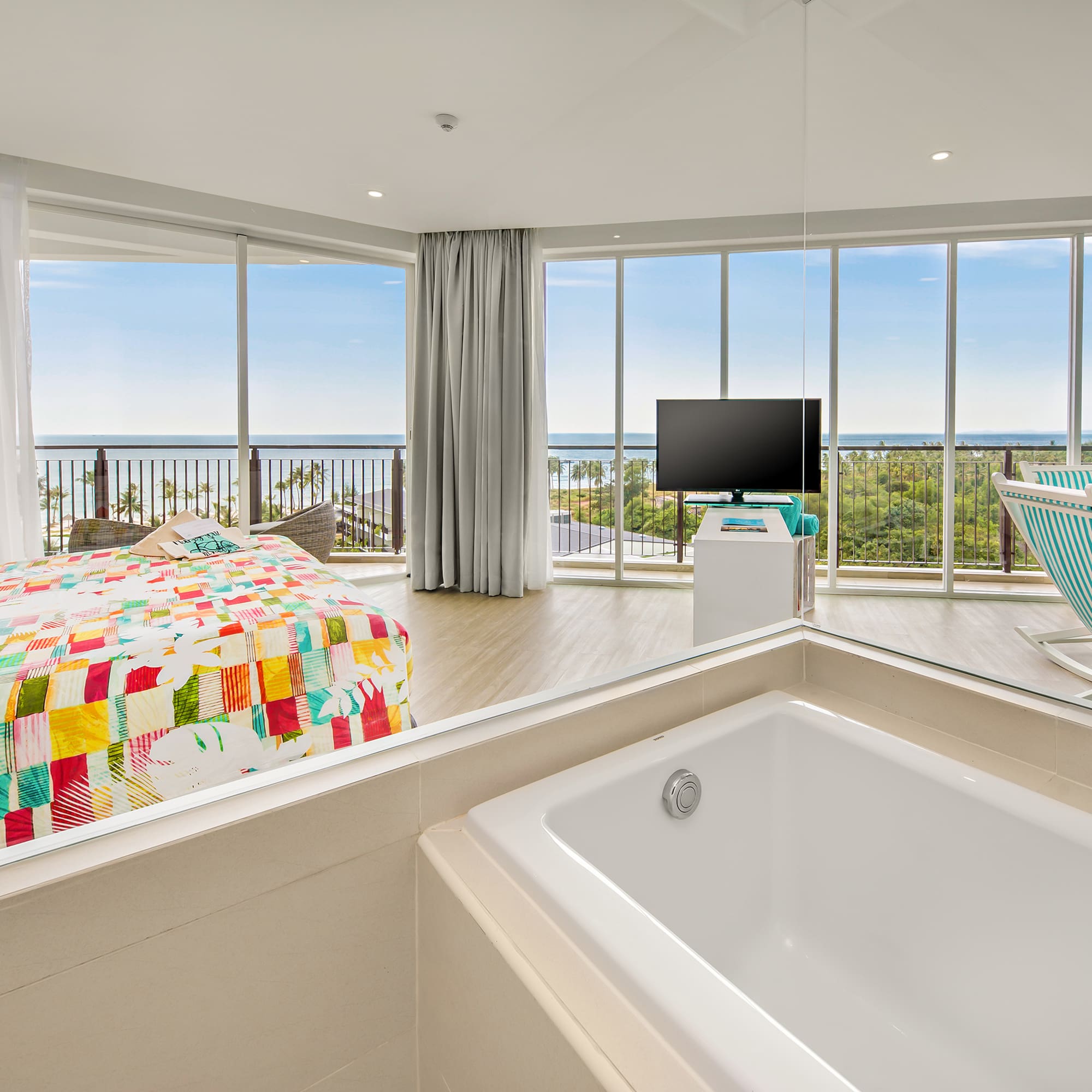 a large room with a bathtub and a television