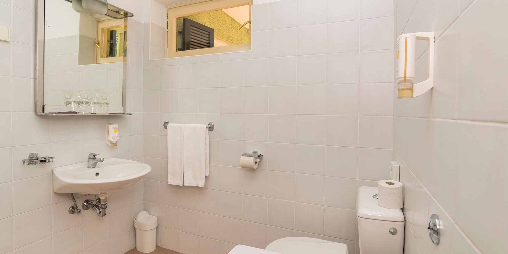 a bathroom with a sink toilet and toilet paper