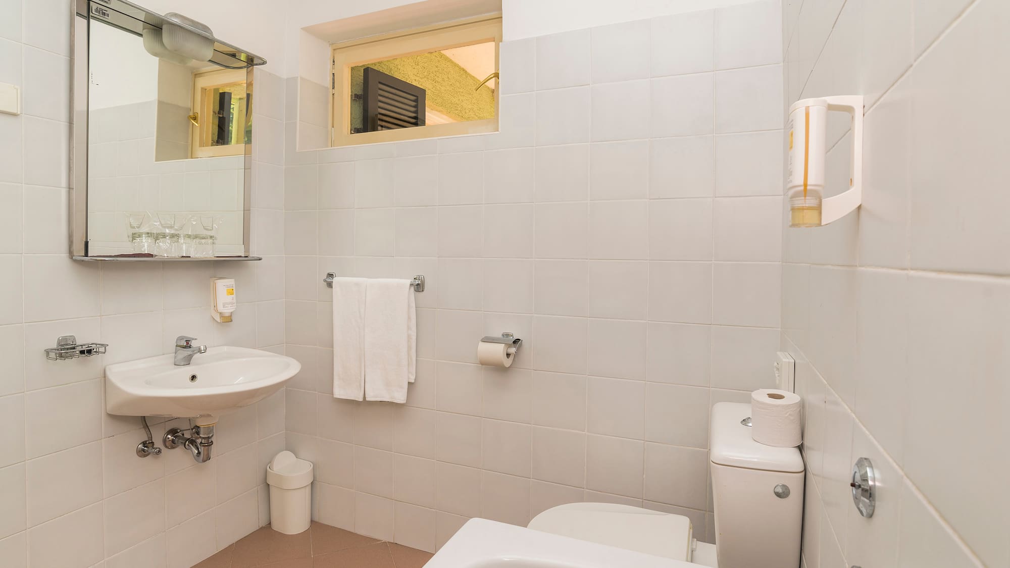 a bathroom with a sink toilet and toilet paper