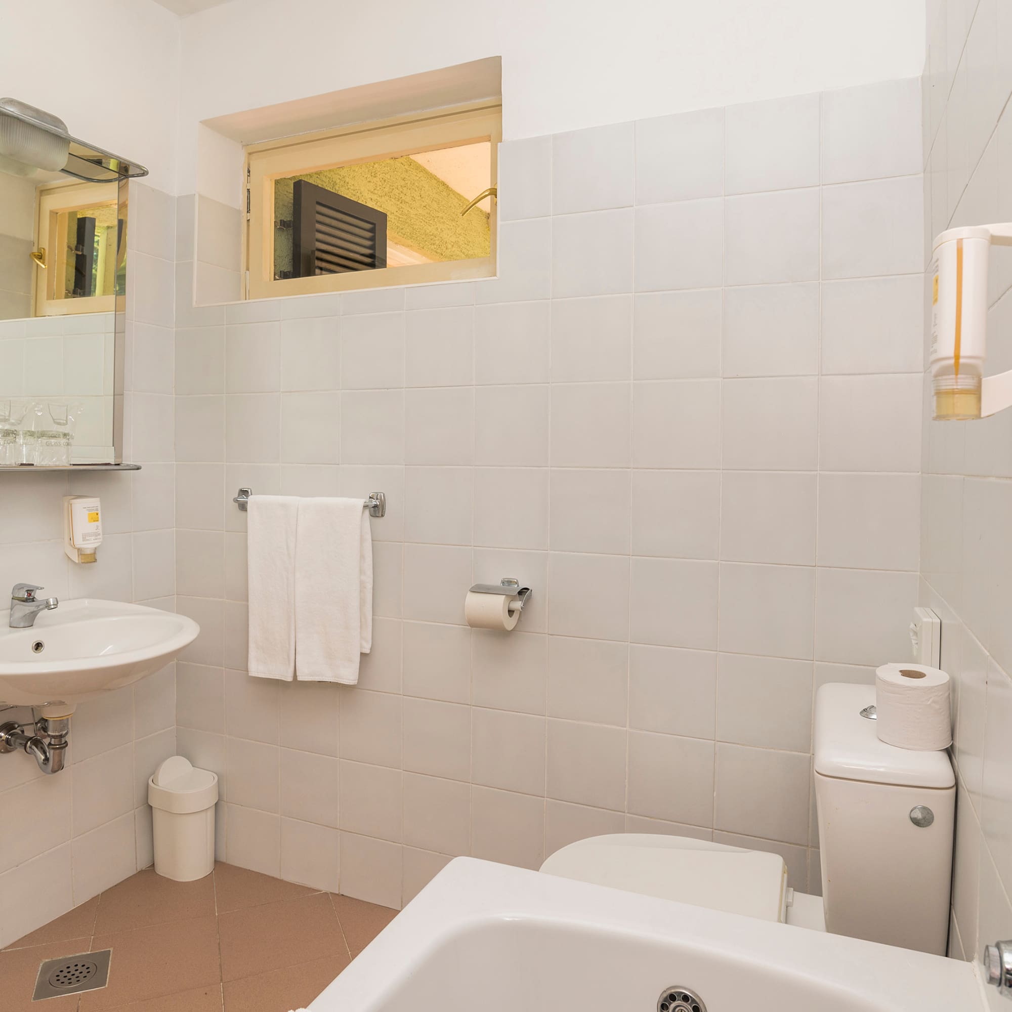 a bathroom with a sink toilet and toilet paper