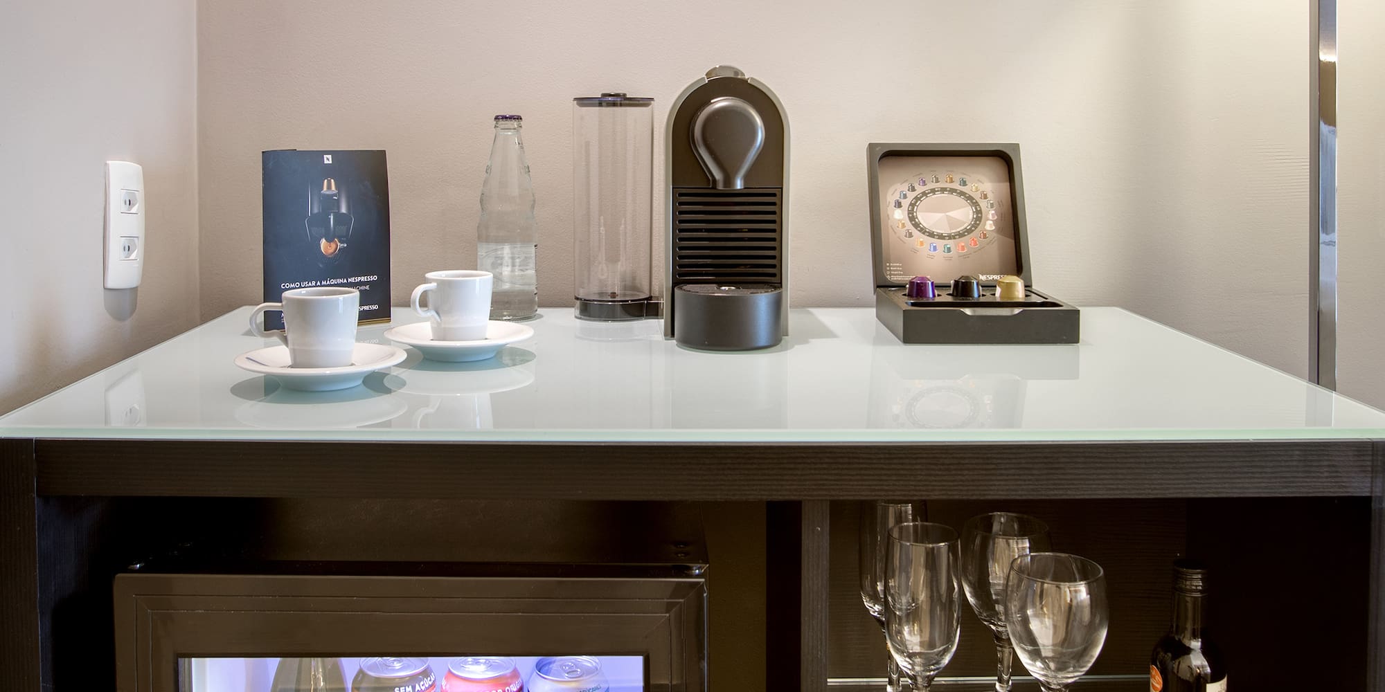 a mini fridge with drinks and cups on top