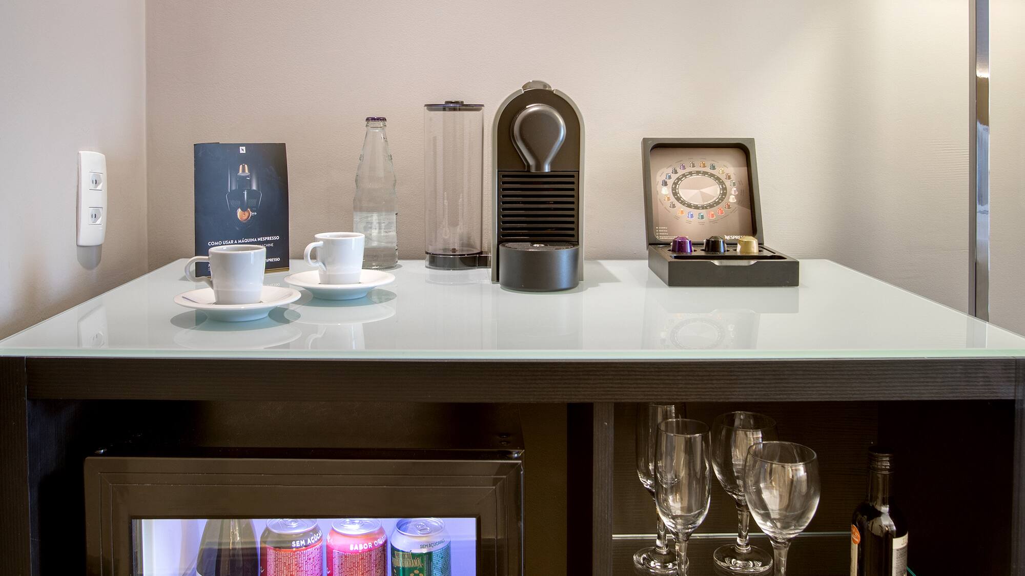 a mini fridge with drinks and cups on top