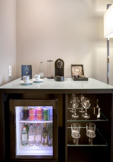 a mini fridge with drinks and cups on top