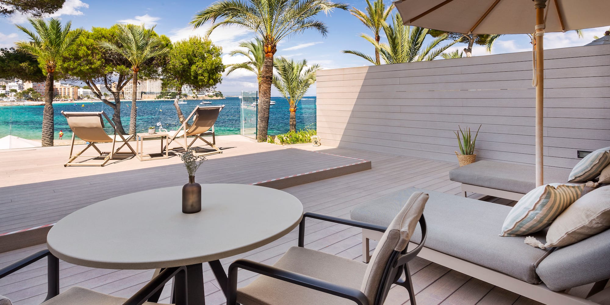 a deck with chairs and a table and umbrella