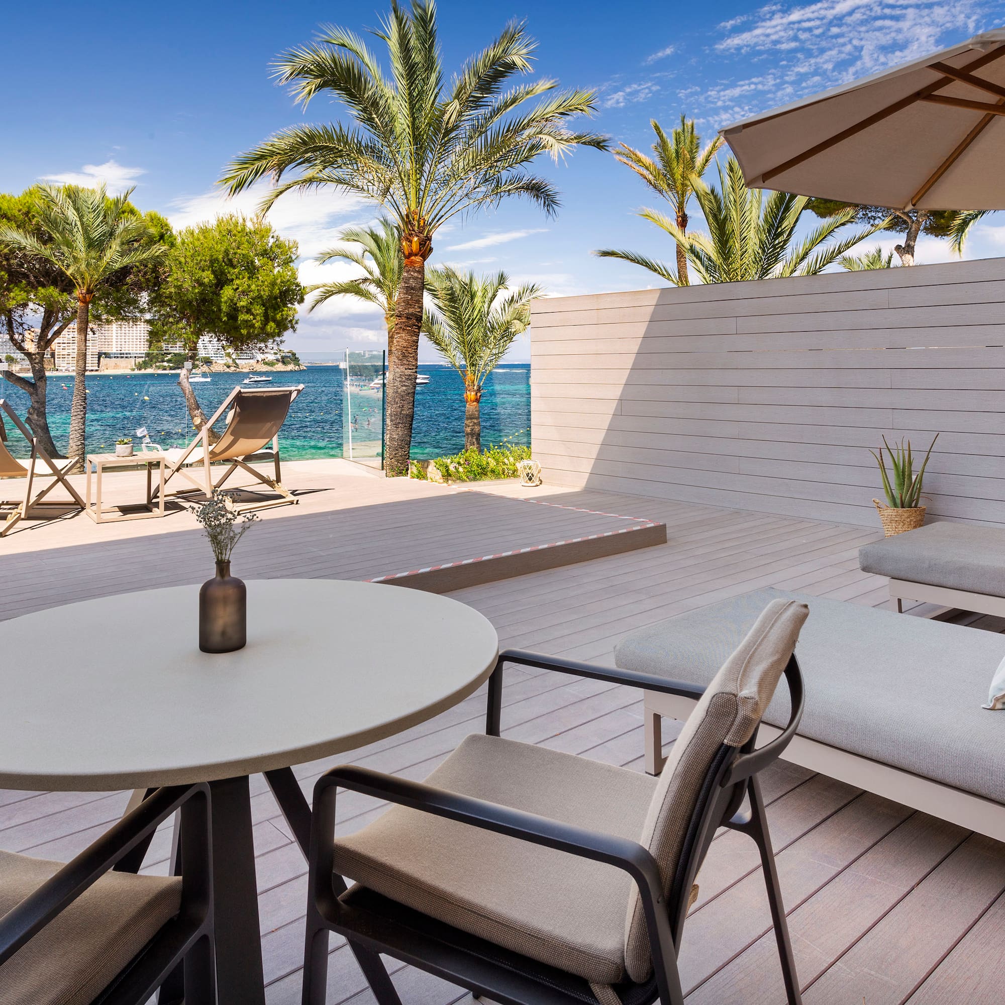 a deck with chairs and a table and umbrella