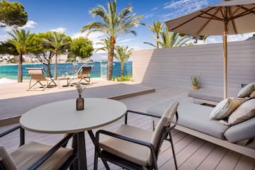 a deck with chairs and a table and umbrella