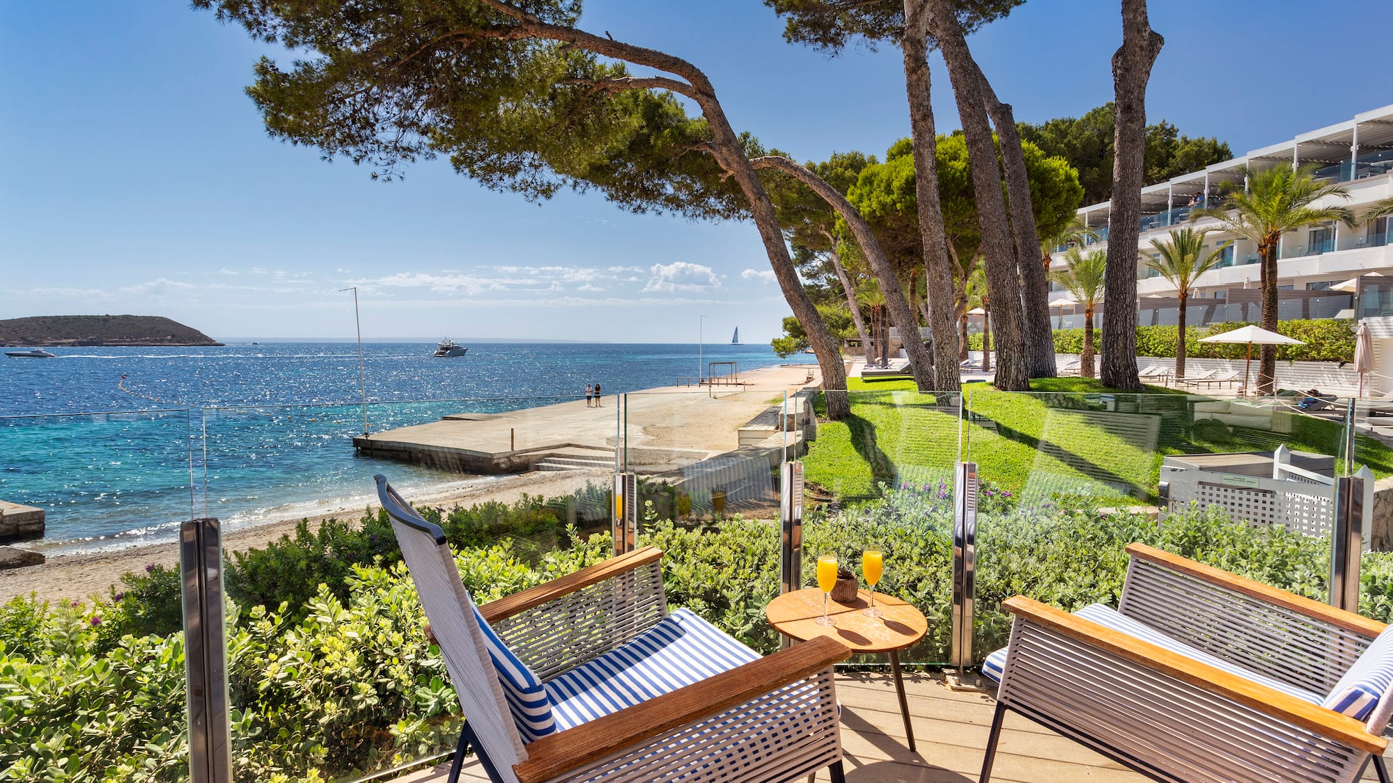 a deck with chairs and a table on a beach