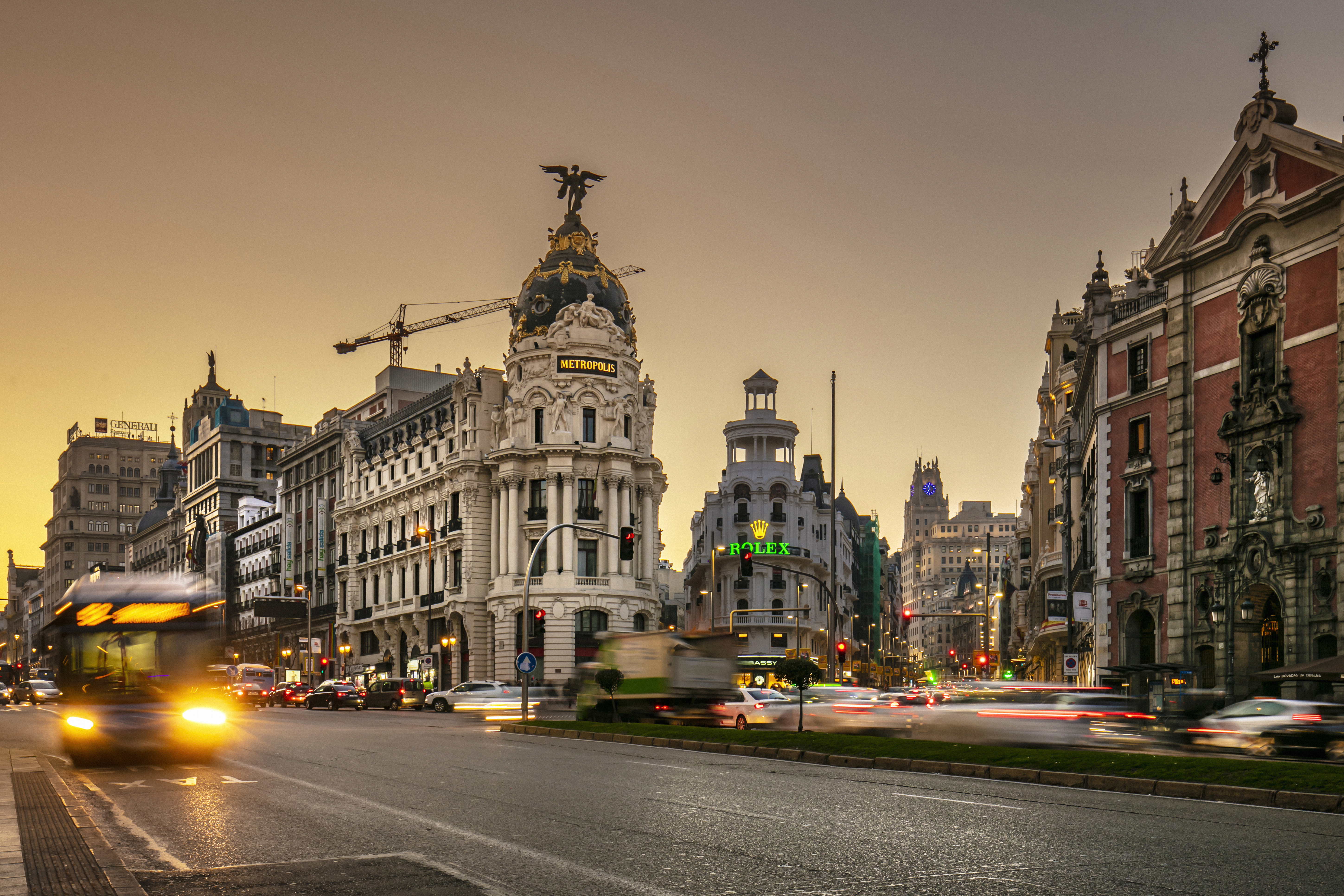 Metrópolis Building on Madrid's Gran Vía at dusk, with blurred city traffic.