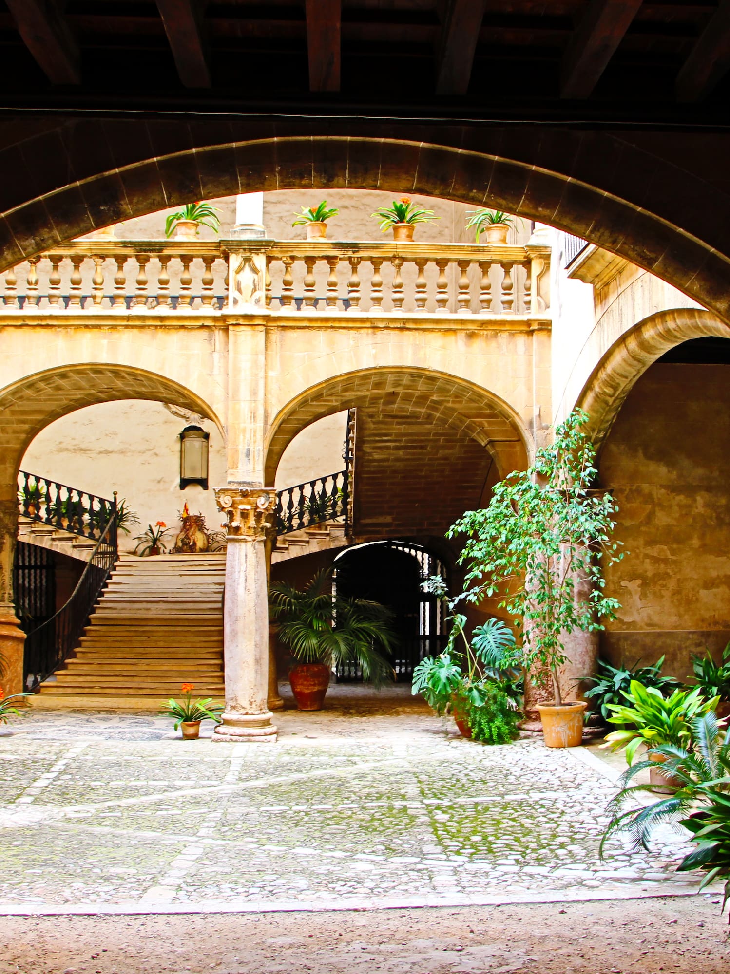 a courtyard with columns and plants