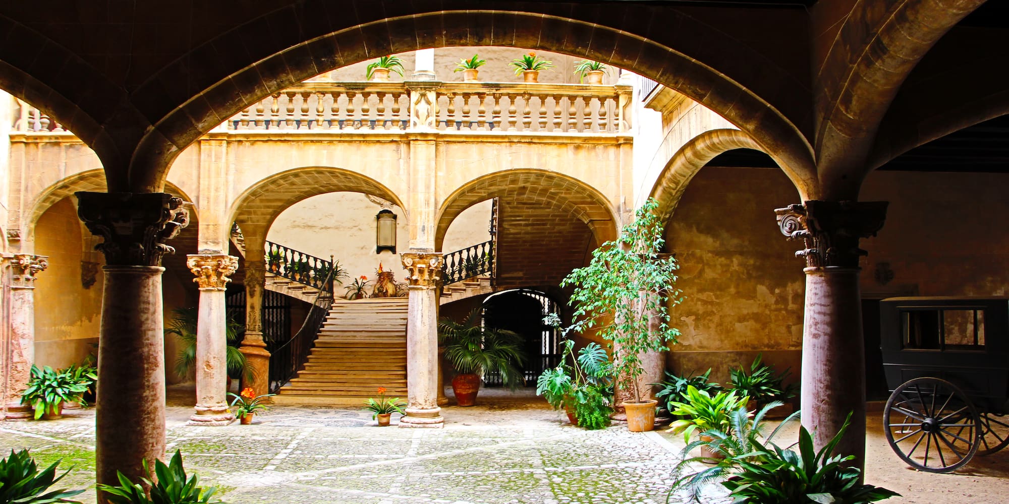 a courtyard with columns and plants