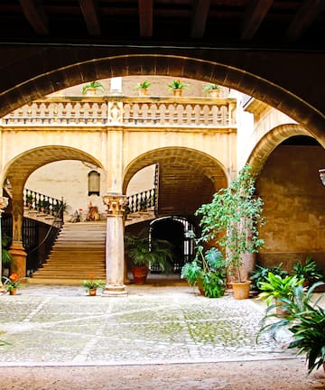 a courtyard with columns and plants