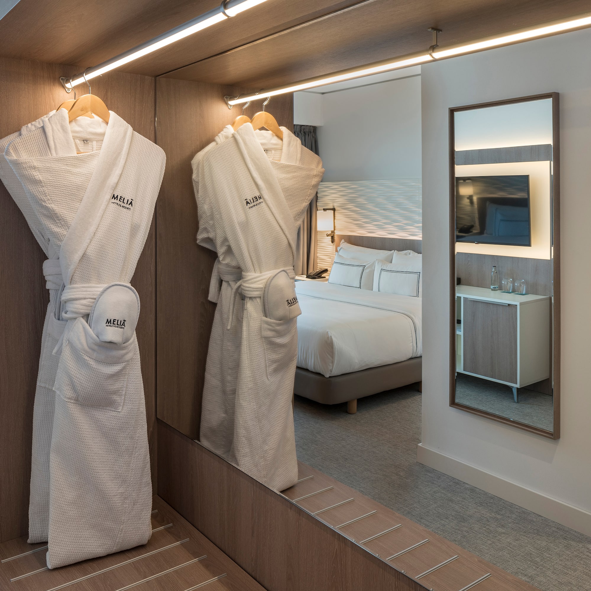 a room with a mirror and white robe