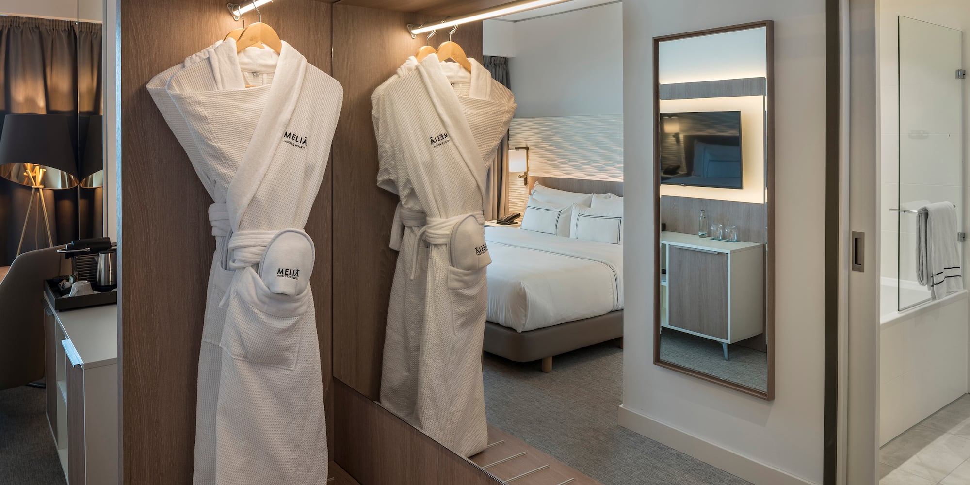a room with a mirror and white robe