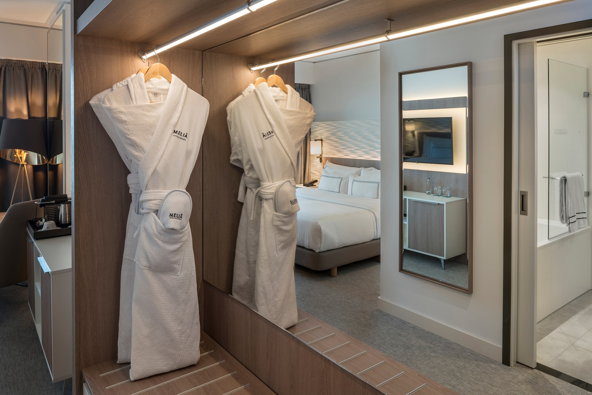 a room with a mirror and white robe