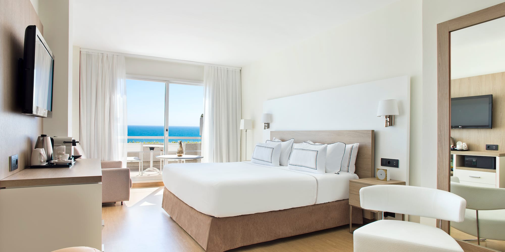 a bedroom with a large bed and a table and chairs