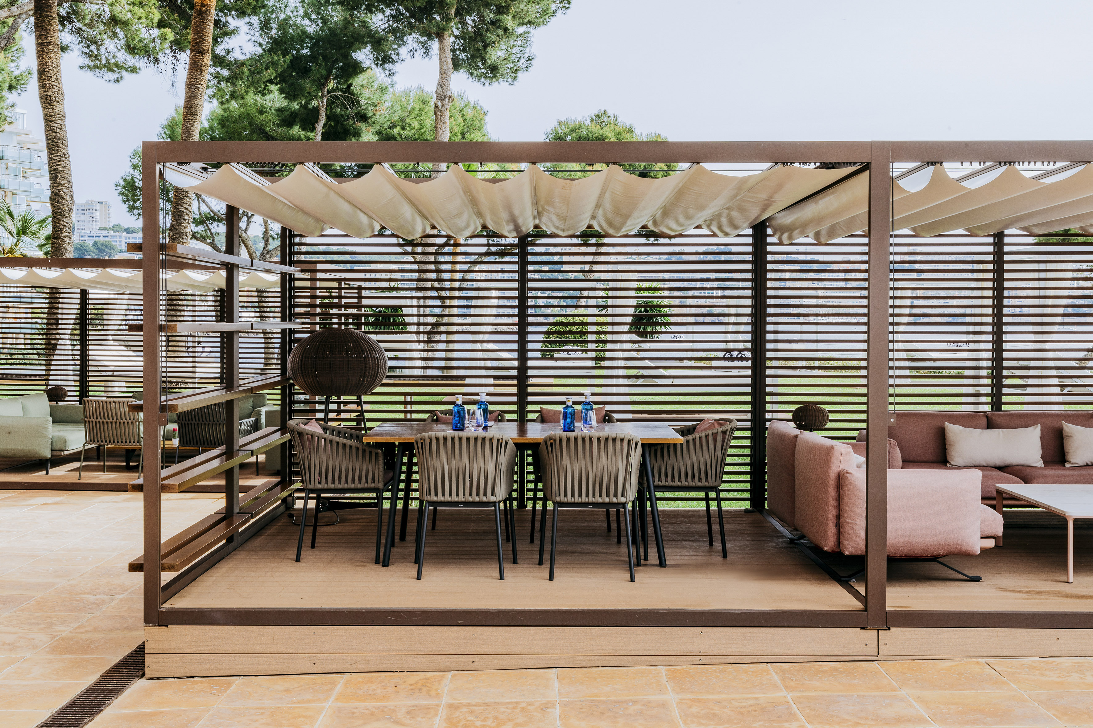 Modern outdoor dining patio with pergola and lounge seating.