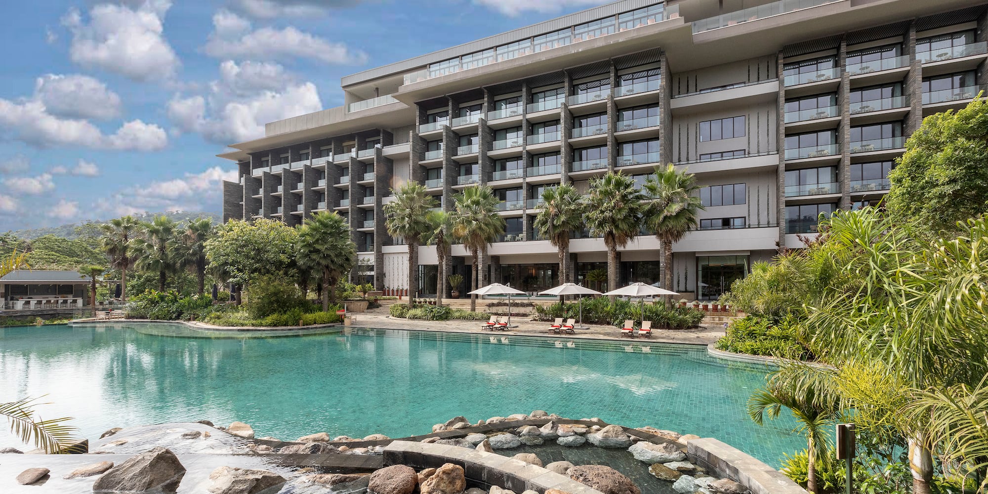 a large building with a pool and trees