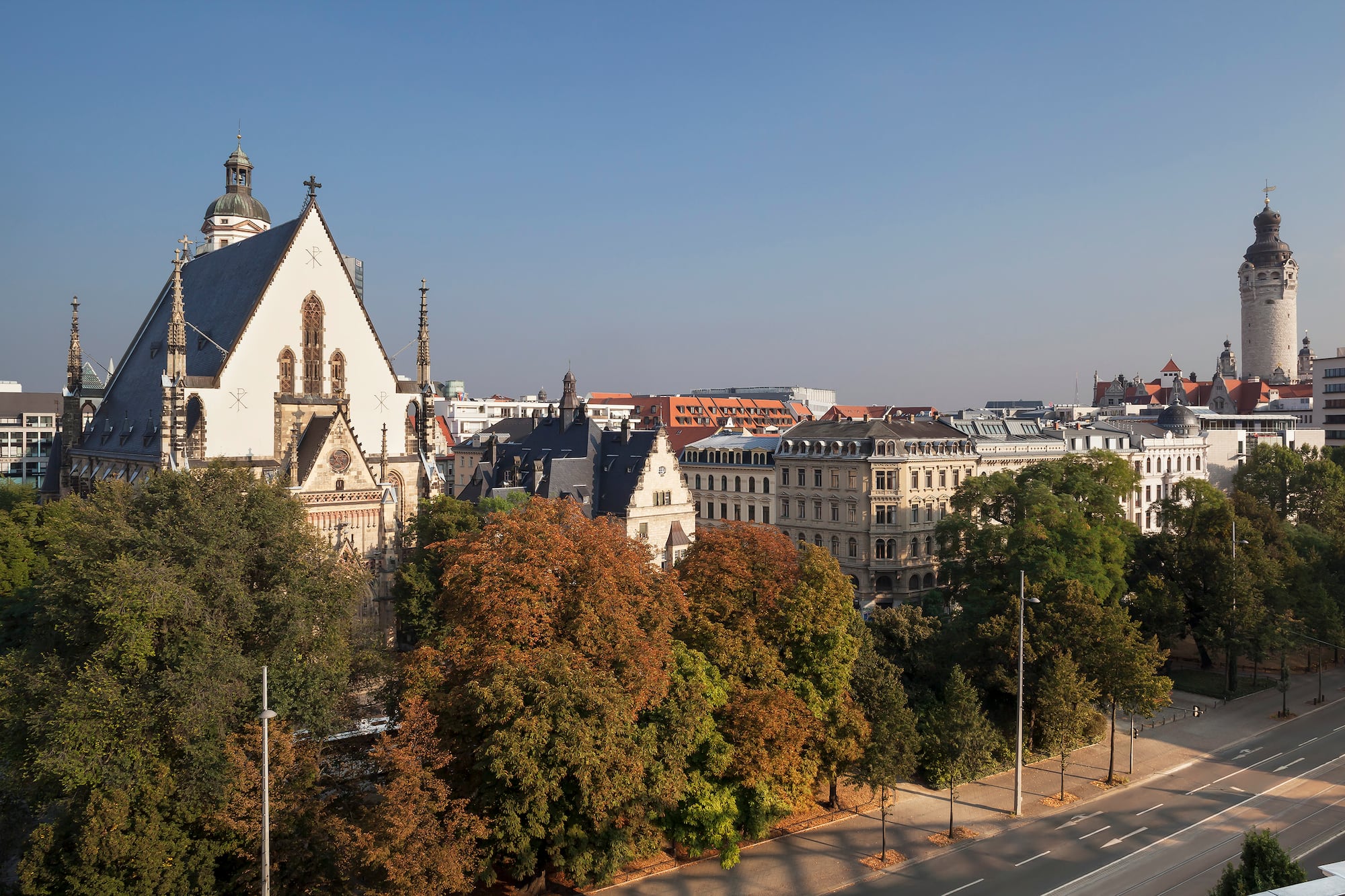 Leipzig cityscape featuring Paulinum, historic architecture, and autumn trees.