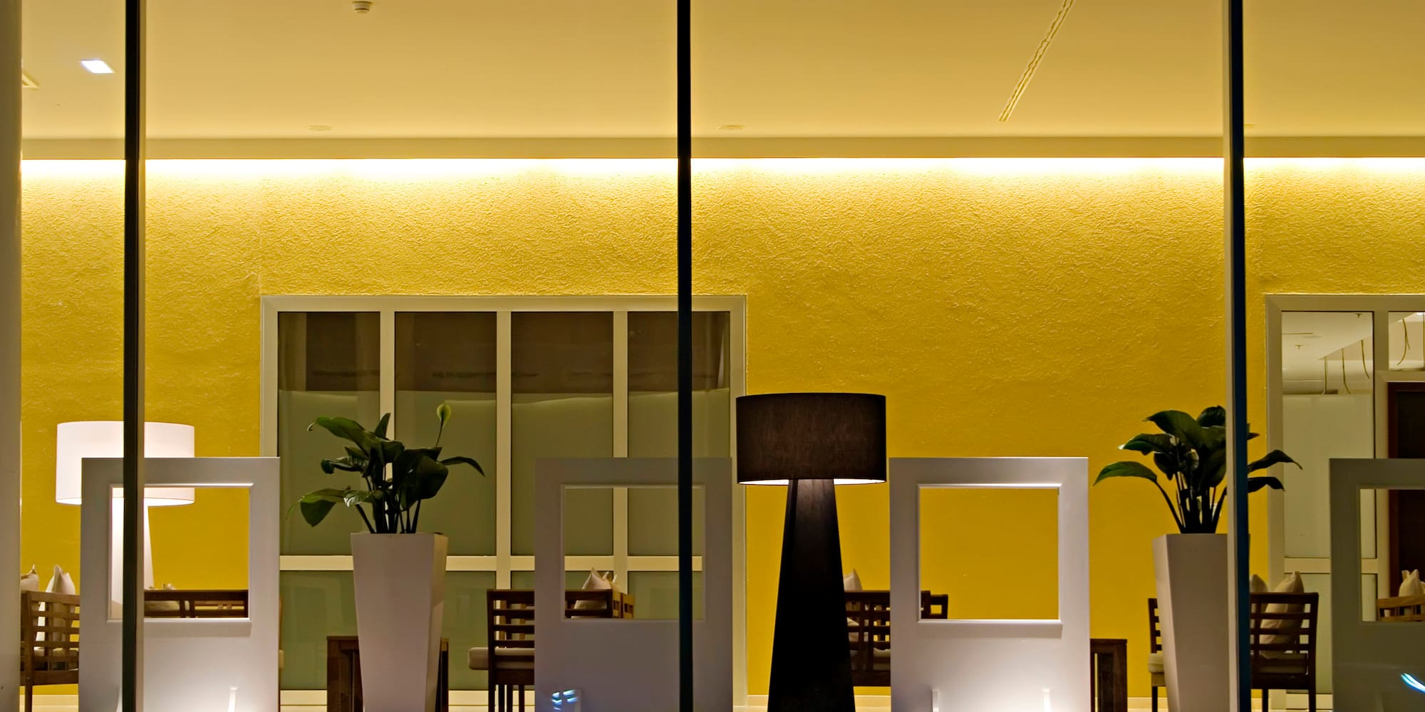 a room with a window with a few white vases and a lamp