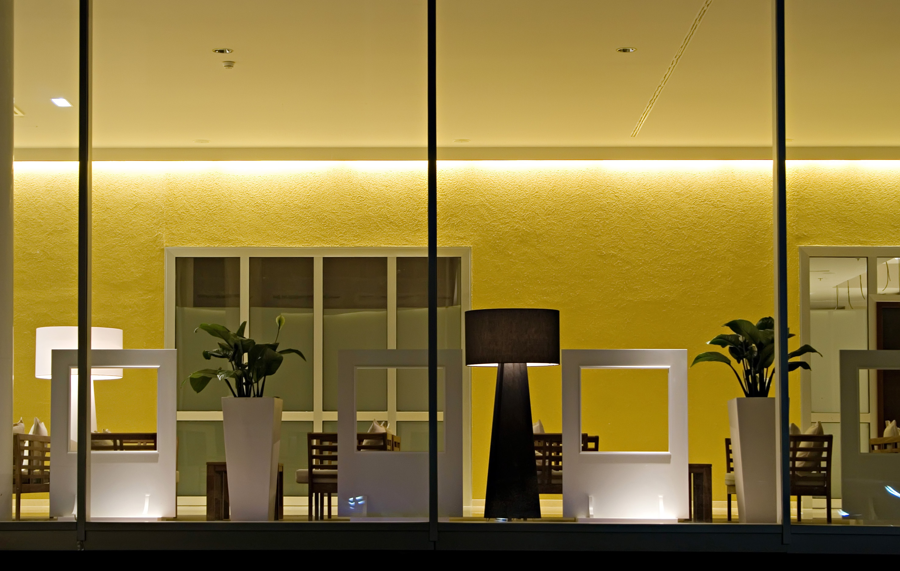 a room with a window with a few white vases and a lamp