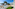 Luxury beachfront resort with pools, hotel, pine trees, and ocean view.