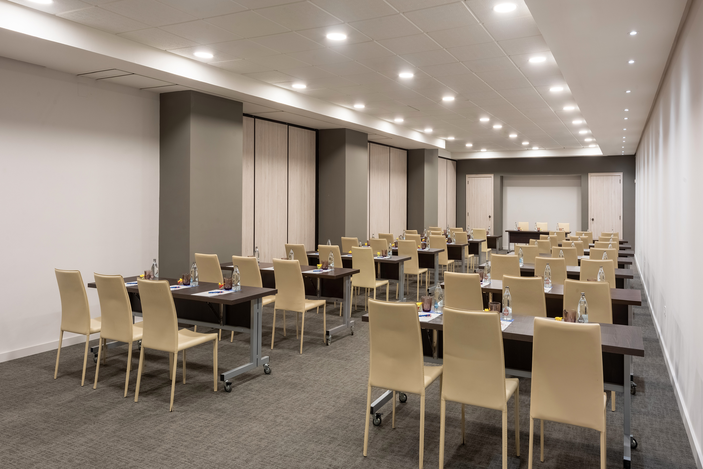 Empty modern conference room with classroom setup tables and chairs.