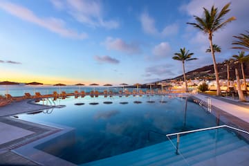 a pool with chairs and a body of water