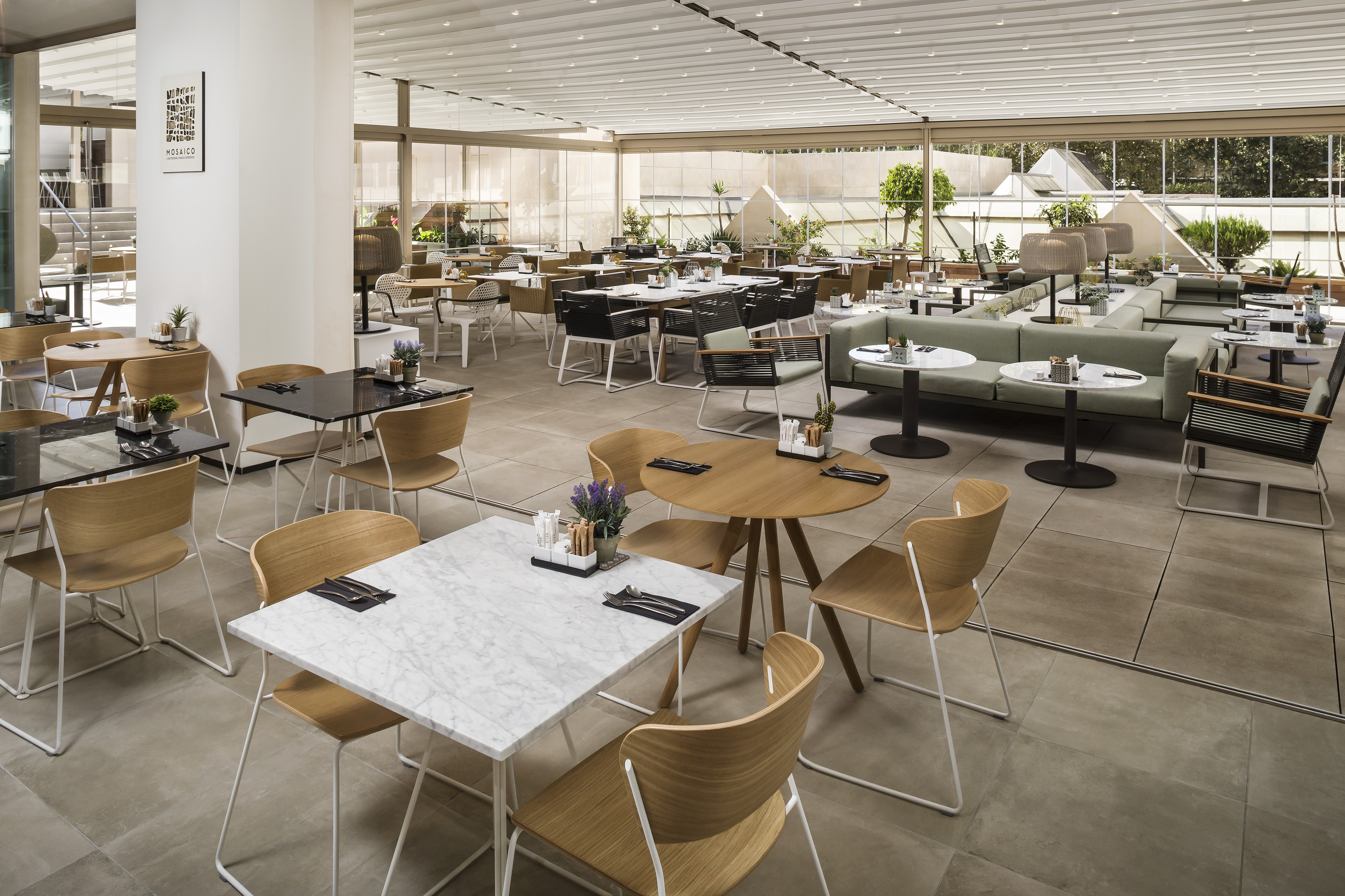 Spacious modern restaurant with various tables, chairs, and bright natural light.
