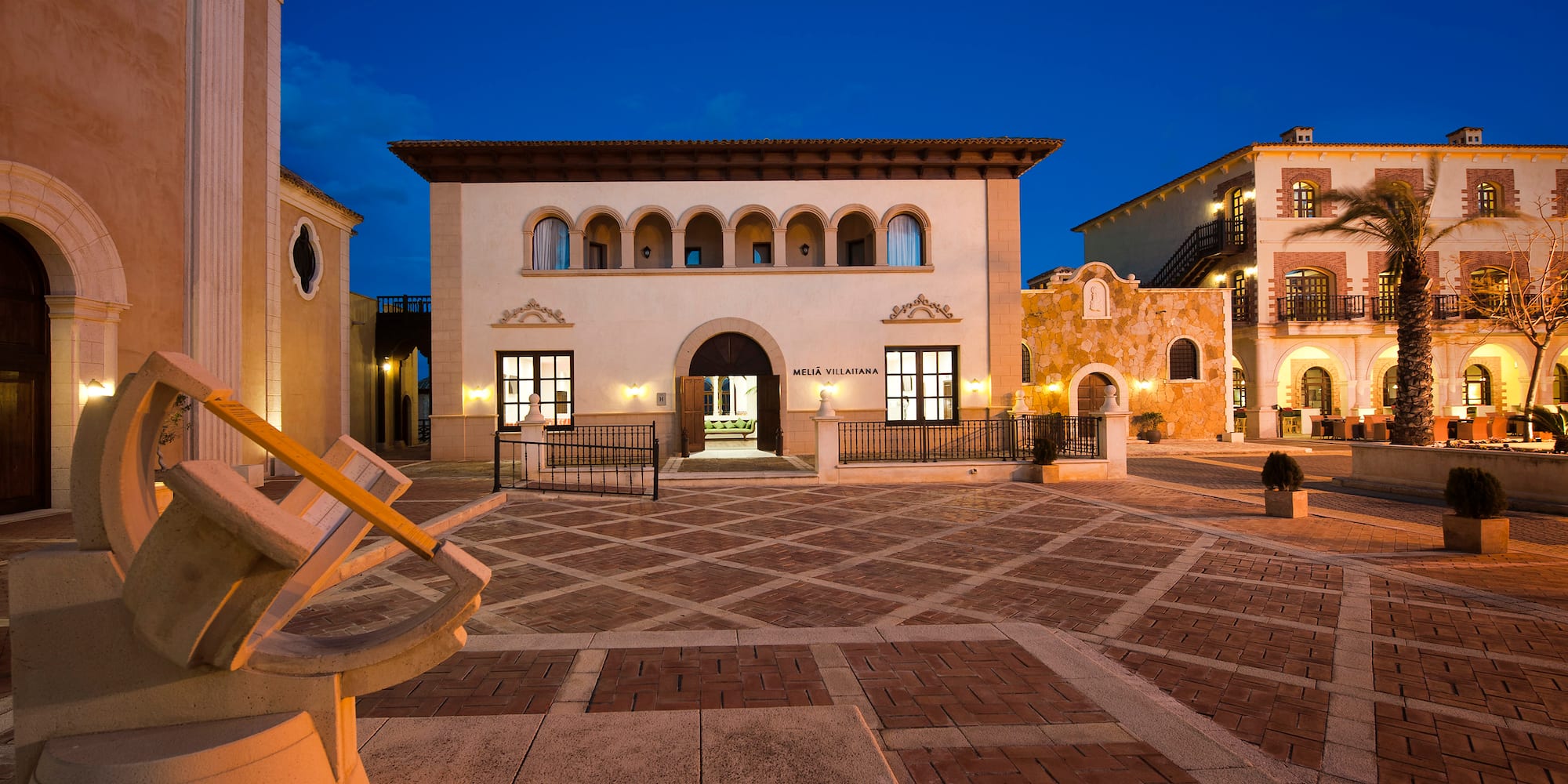 a courtyard with buildings and lights