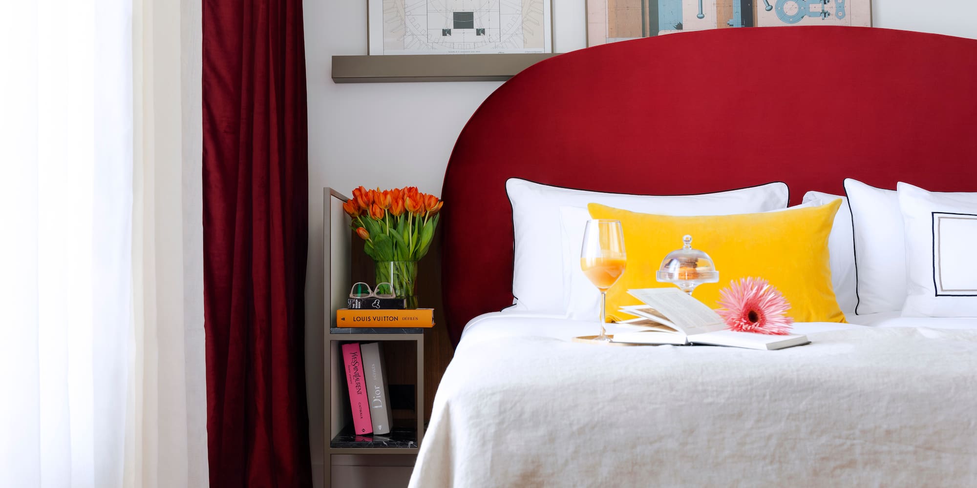 a bed with a glass of wine and a book on it